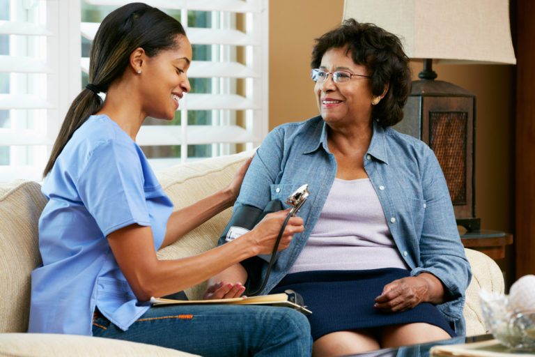 Aide visiting with female patient at home